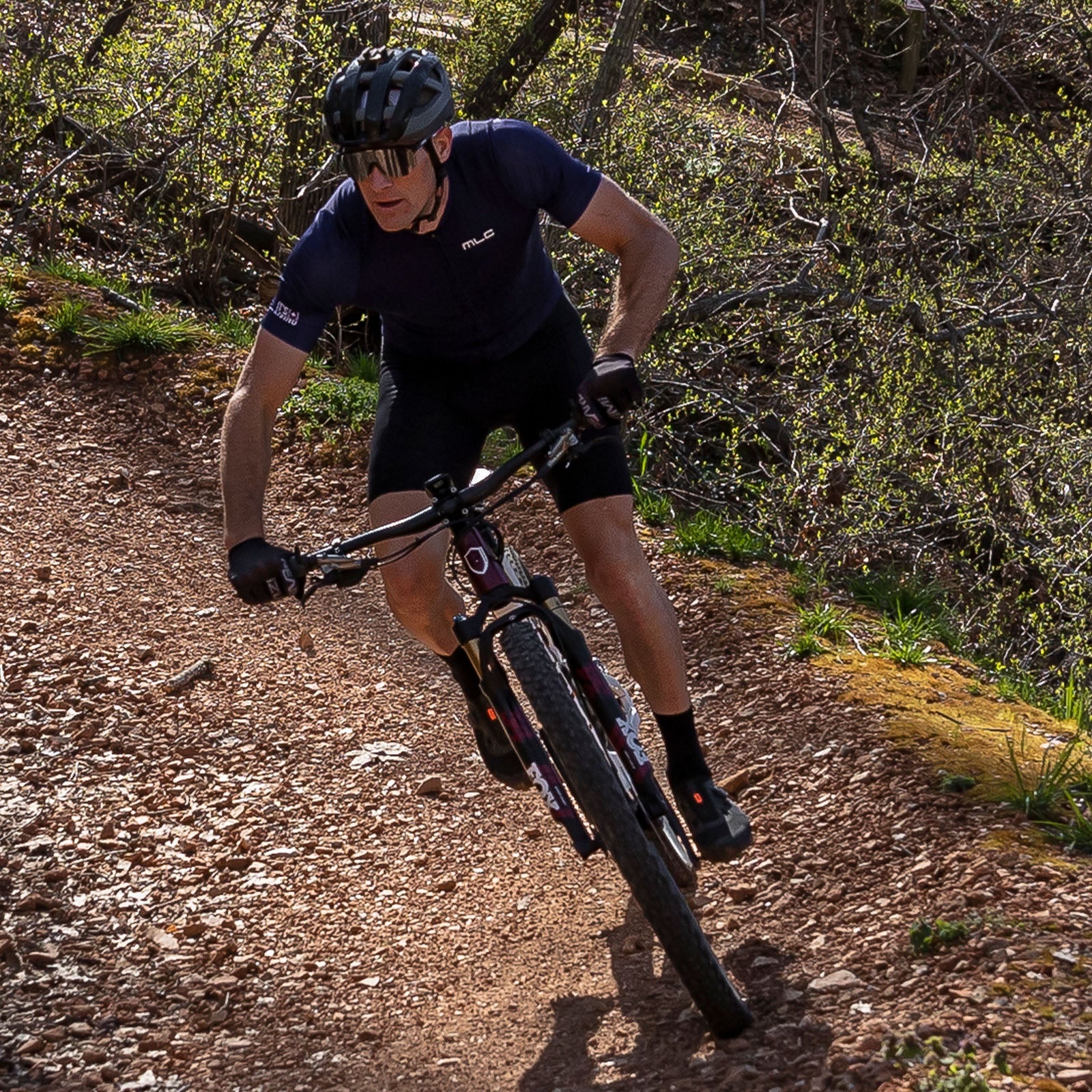 Cyclist riding a mountain bike down a wooded trail
